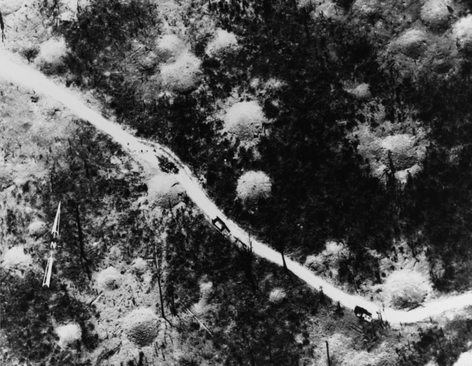 Aerial photograph of camouflaged trucks on the trail in Laos